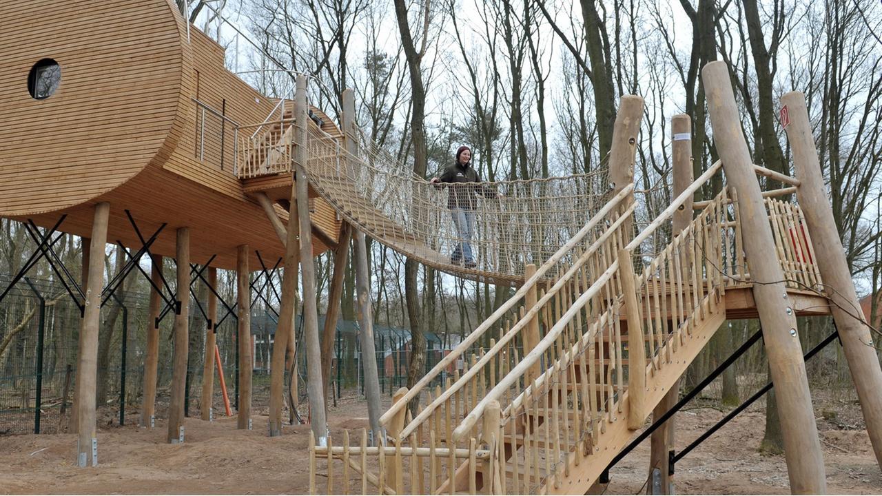 Christina Faß geht am Montag (02.04.2012) über eine Hängebrücke vom neuen Baumhaushotel im Wolfcenter in Dörverden, das sie mit ihrem Mann gegründet hat. In sicherer Höhe kann man direkt auf ein Gehege mit Wölfen blicken.