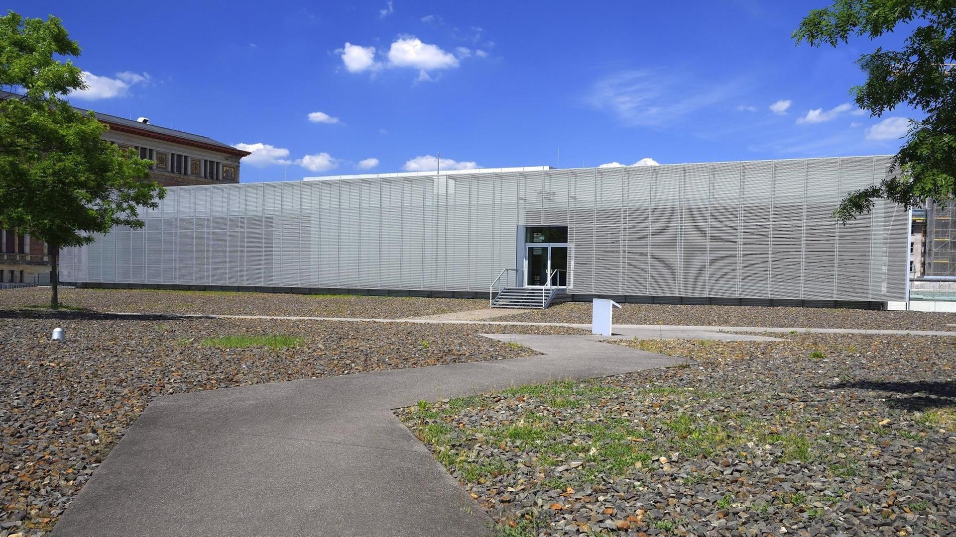 Das Dokumentationszentrum Topographie des Terrors, ein schlichter grauer Bau, ist im Hintergrund zu sehen. Ein Weg führt dorthin. Das Dokumentationszentrum Topographie des Terrors, ein schlichter grauer Bau, ist im Hintergrund zu sehen. Ein Weg führt dorthin.