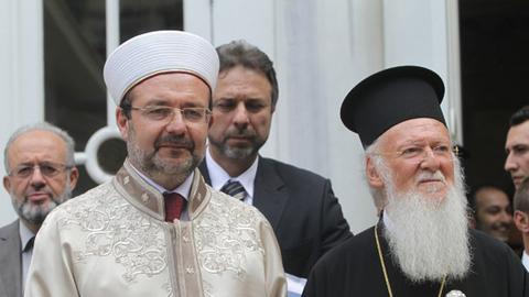 Mehmet Görmez, Mann mit weißem Hut und hellem Gewand neben Bartholomäus, Mann mit schwarzem Hut, schwarzem Gewand und langem weißem Bart
