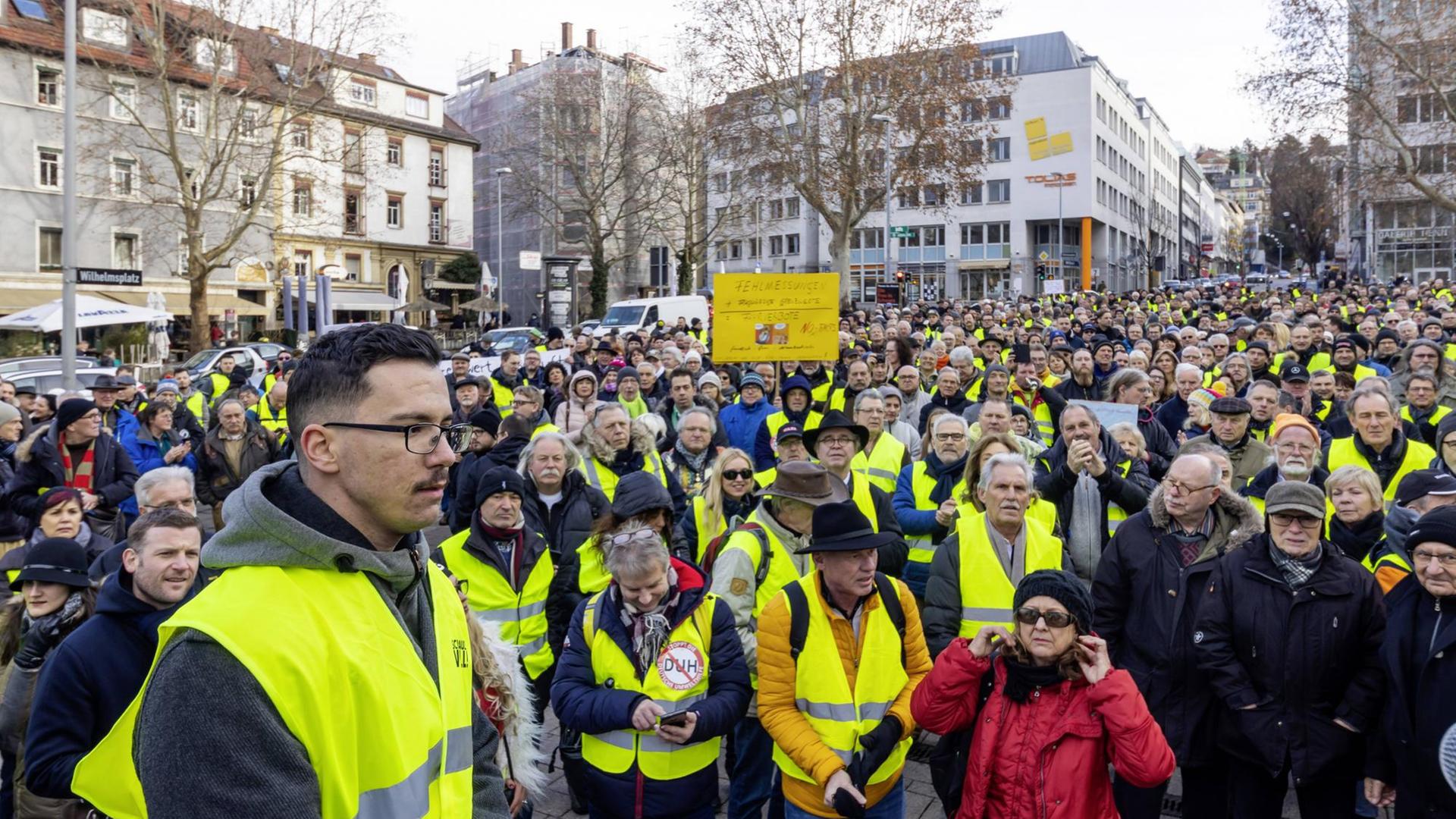 Demo-Organisator Ioannis Sakkaros in gelber Wüste vor einer Gruppe Demonstranten, von denen ebenfalls viele gelbe Westen tragen. Demo-Organisator Ioannis Sakkaros in gelber Wüste vor einer Gruppe Demonstranten, von denen ebenfalls viele gelbe Westen tragen.