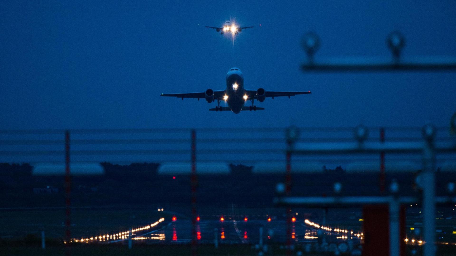 Ein Flugzeug startet in der Dunkelheit auf dem Hamburger Flughafen