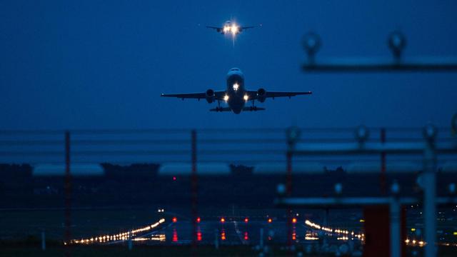 Ein Flugzeug startet in der Dunkelheit auf dem Hamburger Flughafen