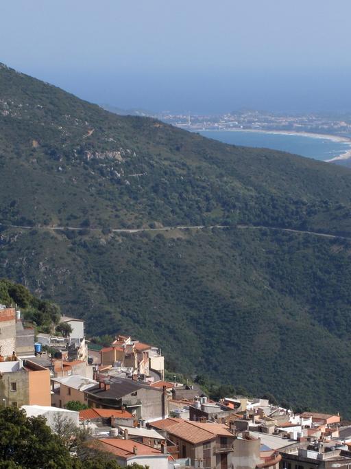 Blick auf die an einem Berghang gelegene Ortschaft Baunei in Sardinien.