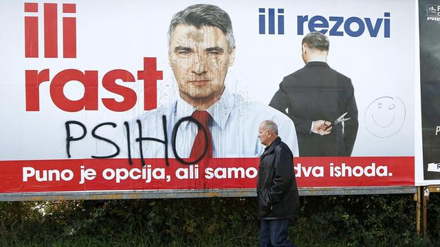 Ein Mann geht an einem Wahlplakat von Zoran Milanovic vorbei