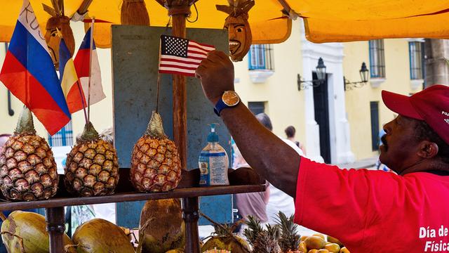 Ein Obst-Verkäufter in Kuba dekoriert seinen Stand mit einer US-Flagge.