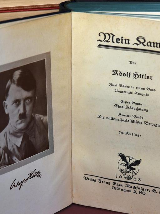 Das geöffnete Buch von Adolf Hitlers Propagandaschrift "Mein Kampf" steht in einem Bücherregal.