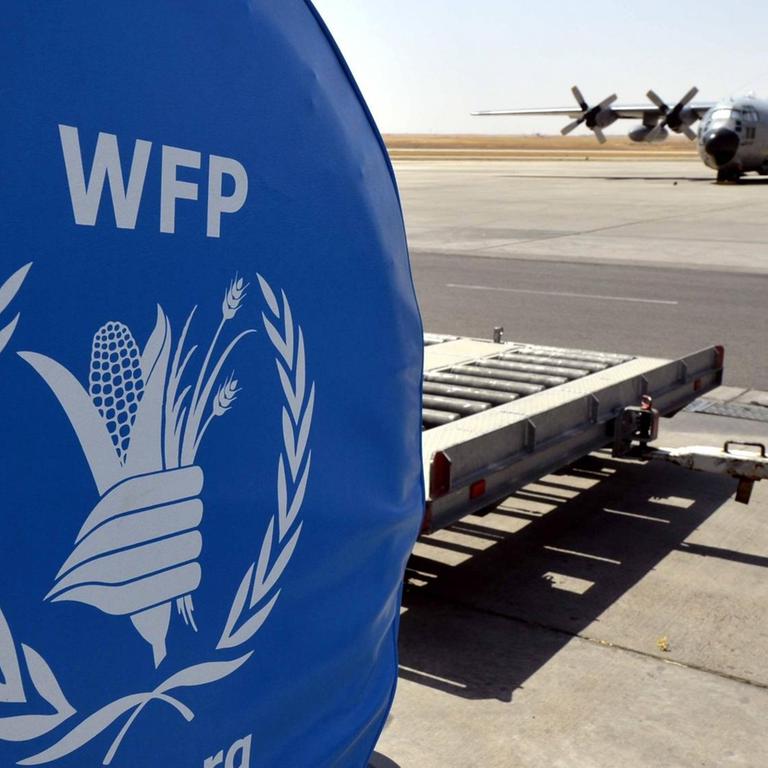 Ein Logo des Welternährungsprogramms World Food Programme und ein belgisches Militärflugzeug auf einem Rollfeld im irakischen Erbil, August 2014