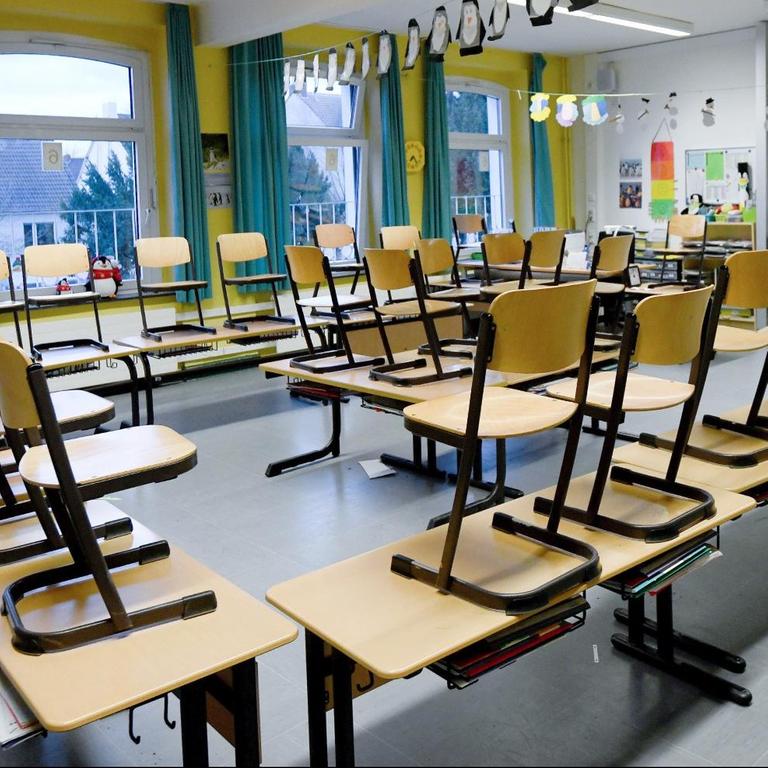 Nordrhein-Westfalen, Gelsenkirchen: Stühle stehen in einem Klassenzimmer in einer Grundschule auf den Tischen.