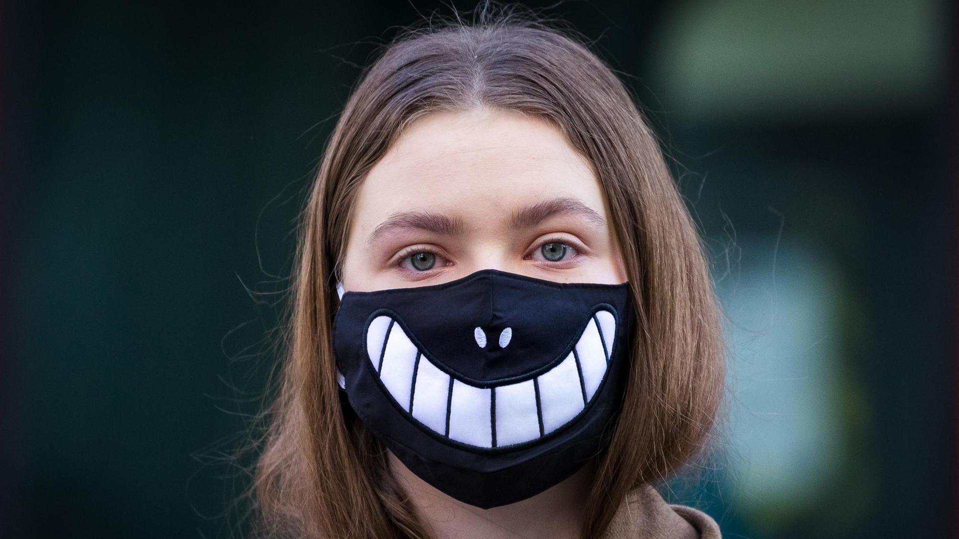 Ein Mädchen trägt eine Halloween-Maske vor dem Gesicht, als Schutz vor dem Corona Virus. London, 16. März 2020 Ein Mädchen trägt eine Halloween-Maske vor dem Gesicht, als Schutz vor dem Corona Virus. London, 16. März 2020