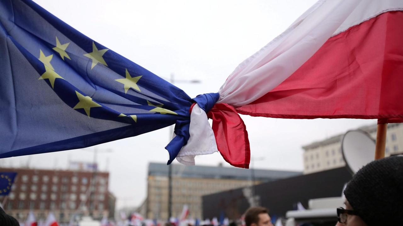 Eine polnische Flagge und eine Europaflagge sind zusammengeknotet.