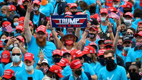 Fans von Donald Trump schwenken Fahnen.