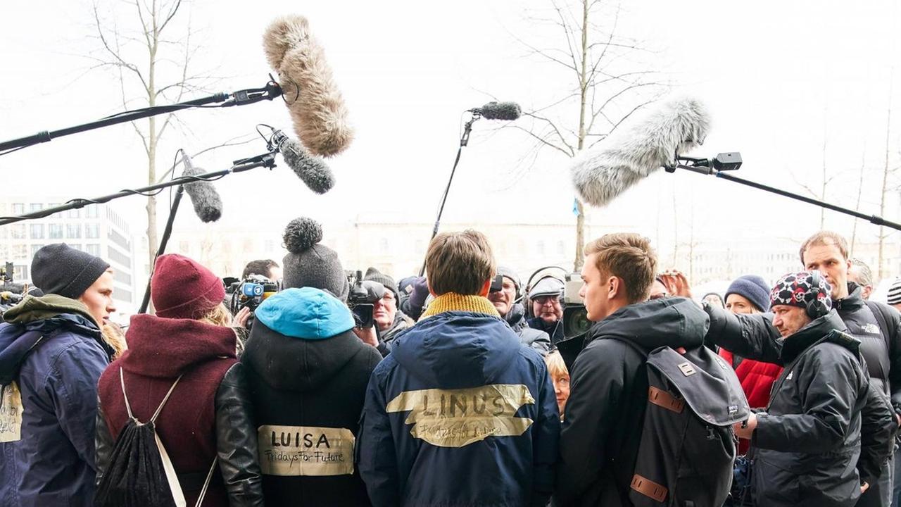 Luisa Neubauer, Linus Steinmetz, Nick Heubeck von Fridays for Future geben Interviews. Sie sind umringt von vielen Reportern mit Kameras und Mikrofonen. Luisa Neubauer, Linus Steinmetz, Nick Heubeck von Fridays for Future geben Interviews. Sie sind umringt von vielen Reportern mit Kameras und Mikrofonen.
