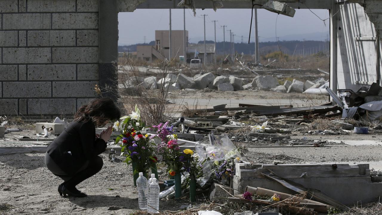 Am vierten Jahrestag erinnert eine Frau in Fukushima mit Blumen an die Reaktorkatastrophe. Am vierten Jahrestag erinnert eine Frau in Fukushima mit Blumen an die Reaktorkatastrophe.