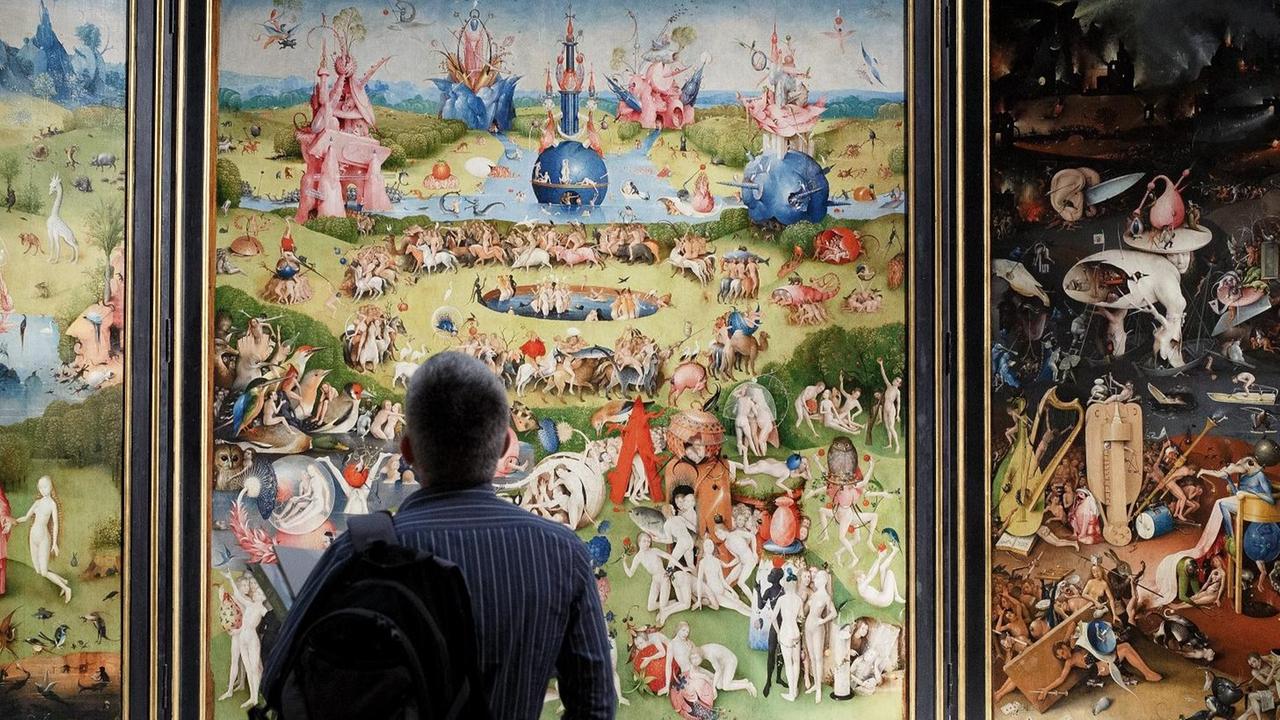 Ein Mann betrachtet Hieronymus Boschs Tryptichon "Garten der Lüste". Ein Mann betrachtet Hieronymus Boschs Tryptichon "Garten der Lüste".