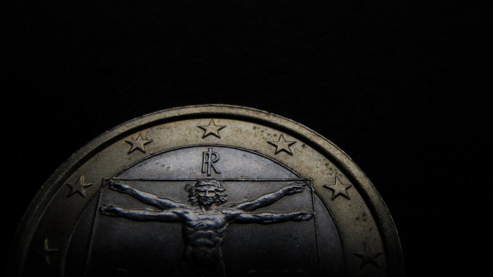 Obere Hälfte einer italienischen Ein-Euro-Münze vor schwarzem Hintergrund. Obere Hälfte einer italienischen Ein-Euro-Münze vor schwarzem Hintergrund.