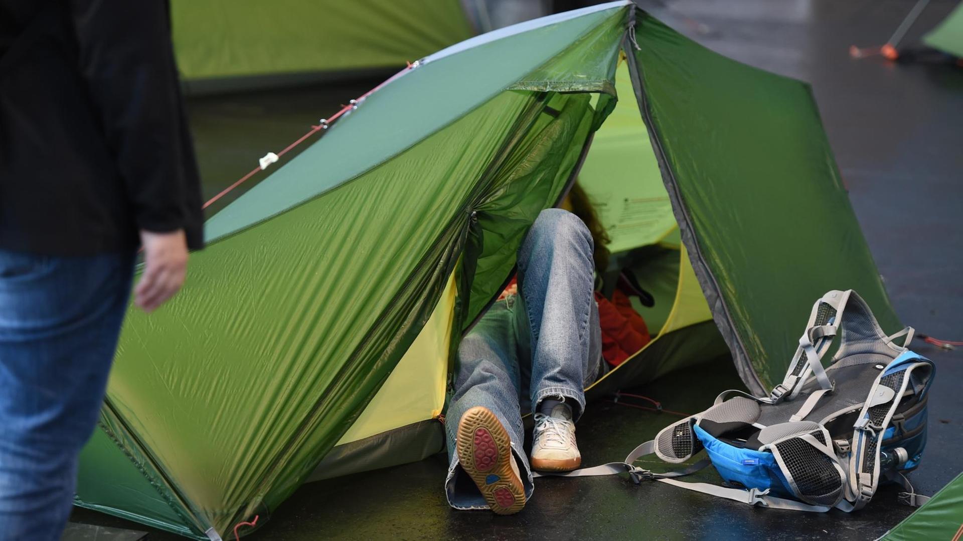 Eine Messebesucherin schaut sich während der Messe Outdoor in Friedrichshafen ein Zelt von innen an.