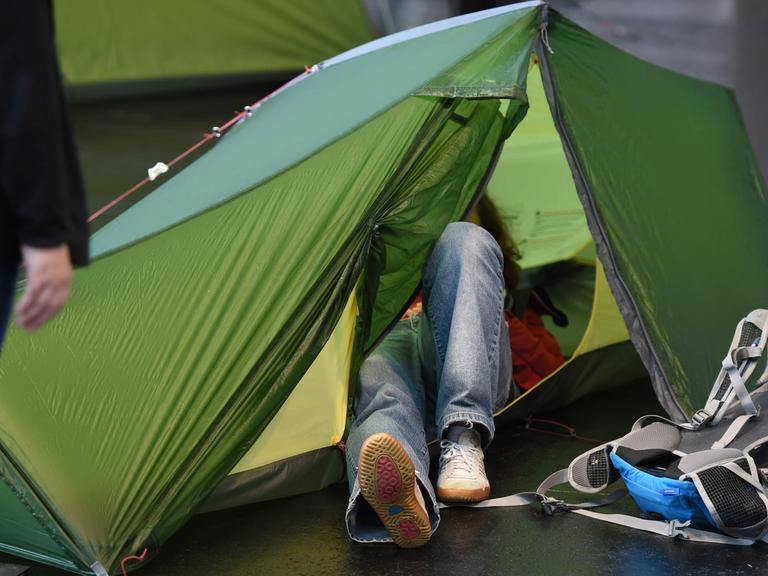 Eine Messebesucherin schaut sich während der Messe Outdoor in Friedrichshafen ein Zelt von innen an.