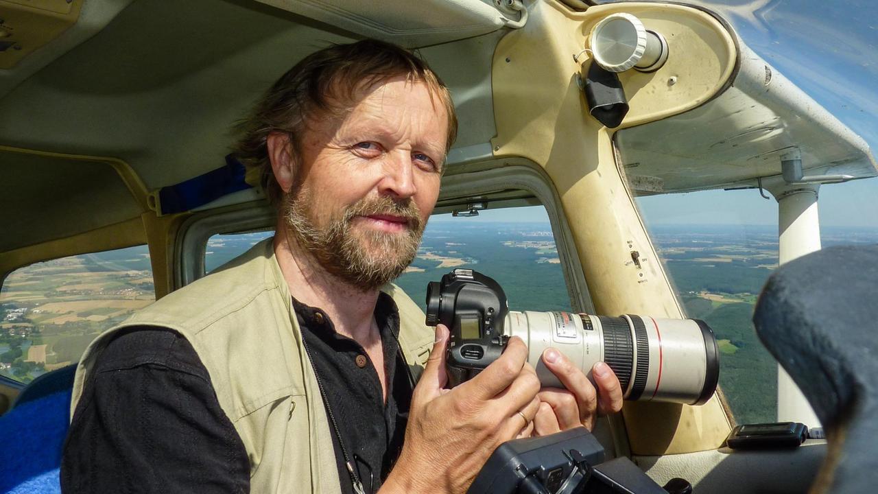 Selbstportrait des Luftbildarchäologen Klaus Leidorf an seinem Arbeitsplatz, einer Cessna 172 in der Luft.