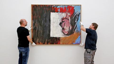 Restaurator Detlef Gösche (l) und Techniker Michael Mehlhorn nehmen am 20.07.2015 das Baselitz-Bild "Blick aus dem Fenster" in den Kunstsammlungen Chemnitz (Sachsen) von der Wand.