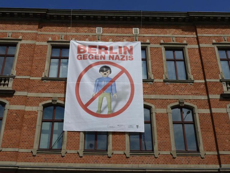 An einem Gebäude hängt ein Poster mit der Aufschrift "Berlin gegen Nazis"