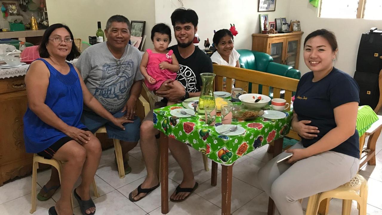 Daisy Agravante sitzt am Osterfest gemeinsam mit ihrer Familie um einen gedeckten Tisch herum. Daisy Agravante sitzt am Osterfest gemeinsam mit ihrer Familie um einen gedeckten Tisch herum.