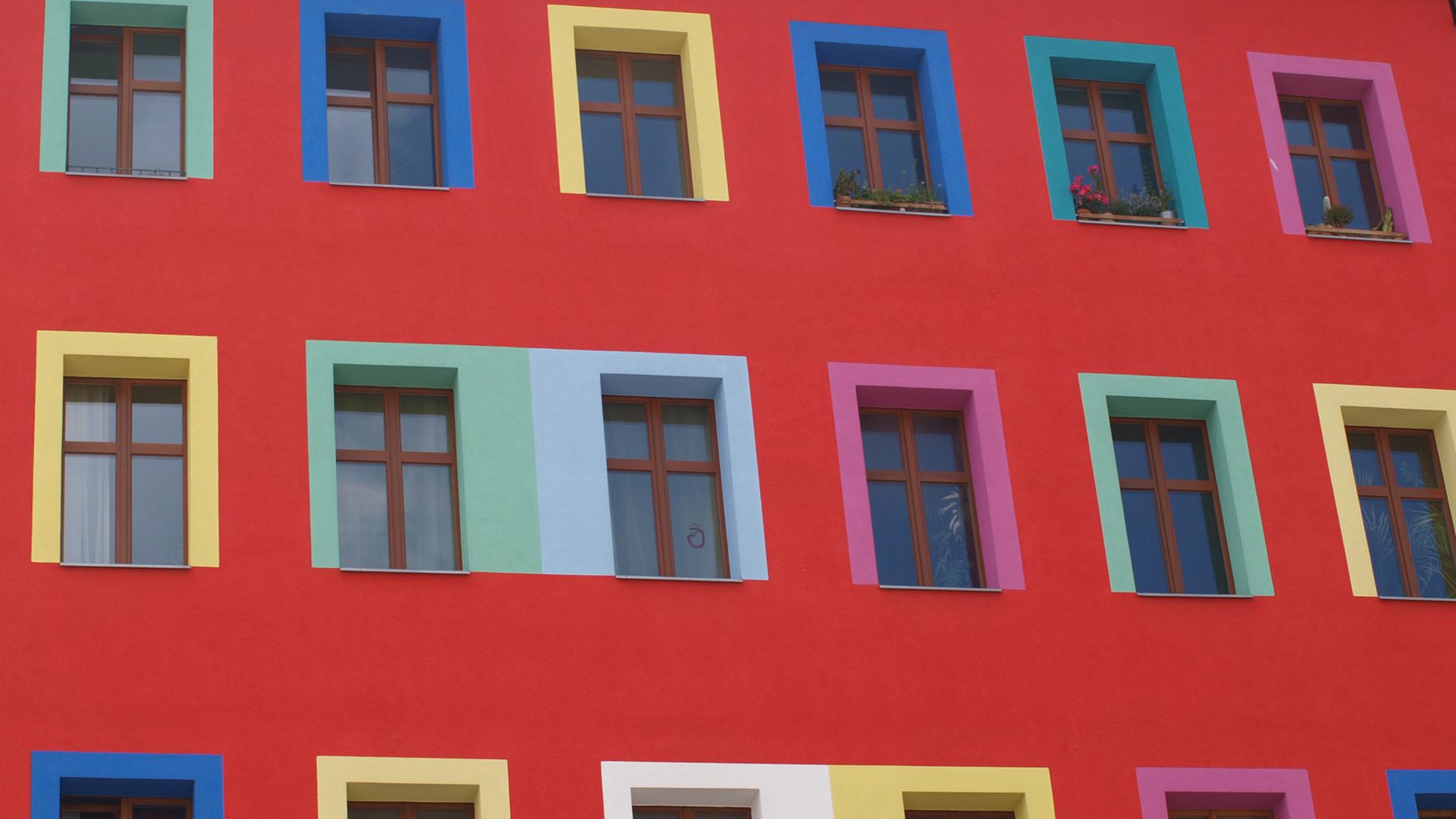 Blick auf die Fassade eines Mehrfamilienhauses mit bunten Fensterrahmen. Blick auf die Fassade eines Mehrfamilienhauses mit bunten Fensterrahmen.