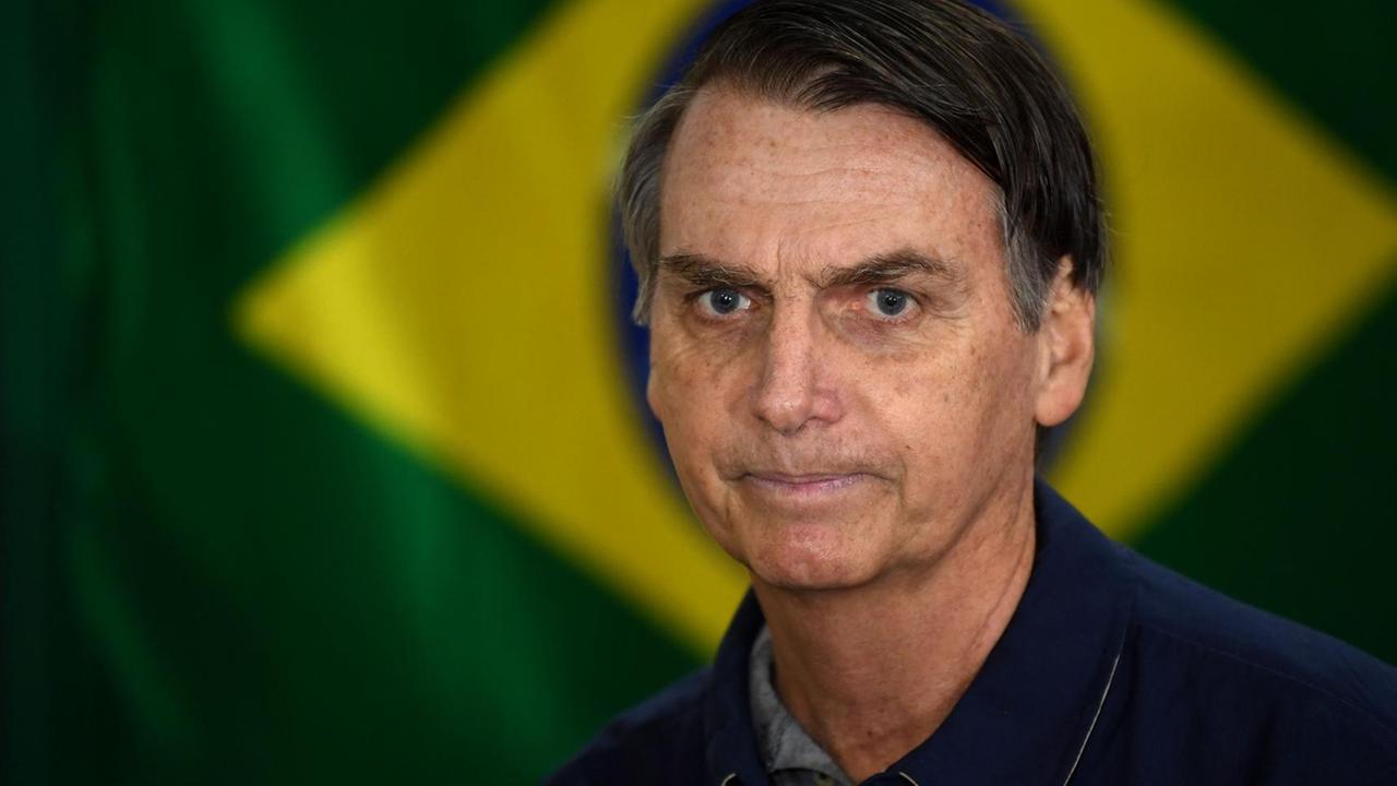 Der brasilianische Präsident Jair Bolsonaro steht vor einer Brasilienflagge. Der brasilianische Präsident Jair Bolsonaro steht vor einer Brasilienflagge.