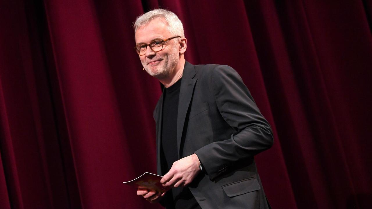 Christoph Terhechte steht auf der Bühne der Berlinale. Er trägt ein schwarzes Sakko und schaut freundlich in das Publikum. Christoph Terhechte steht auf der Bühne der Berlinale. Er trägt ein schwarzes Sakko und schaut freundlich in das Publikum.