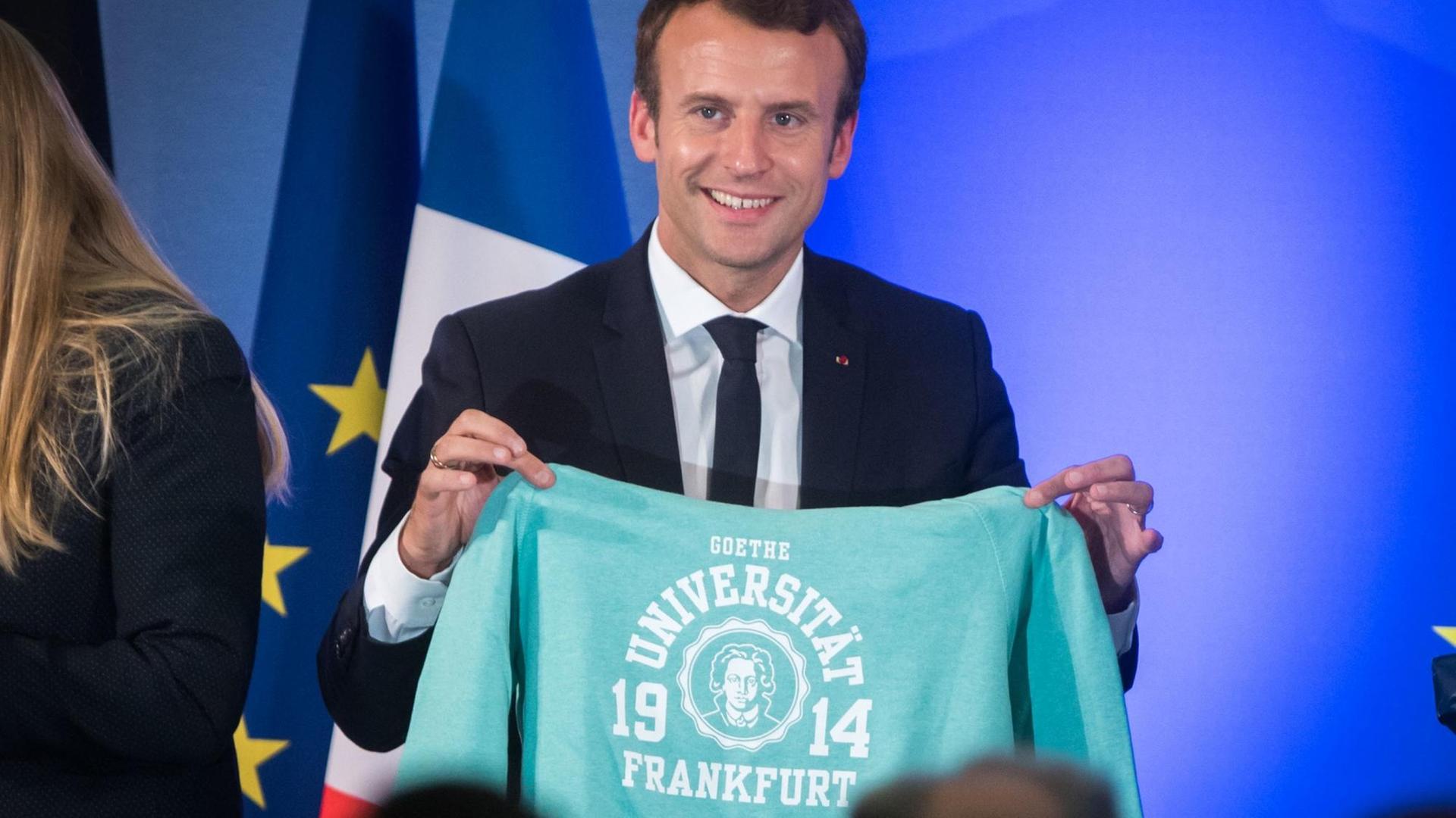 Frankreichs Staatspräsident Emmanuel Macron steht am 10.10.2017 in Frankfurt am Main (Hessen) an der Johann Wolfgang Goethe-Universität mit einem Pullover der Uni auf der Bühne, die er zum Abschluss einer Diskussion von Sudenten geschenkt bekam. Am 18. Oktober 1914 wurde die Universität eröffnet. Das Thema der Festveranstaltung lautete "Debatte über die Zukunft Europas". Macron wird anschließend die Frankfurter Buchmesse eröffnen, deren Gastland in diesem Jahr Frankreich ist. Frankreichs Staatspräsident Emmanuel Macron steht am 10.10.2017 in Frankfurt am Main (Hessen) an der Johann Wolfgang Goethe-Universität mit einem Pullover der Uni auf der Bühne, die er zum Abschluss einer Diskussion von Sudenten geschenkt bekam. Am 18. Oktober 1914 wurde die Universität eröffnet. Das Thema der Festveranstaltung lautete "Debatte über die Zukunft Europas". Macron wird anschließend die Frankfurter Buchmesse eröffnen, deren Gastland in diesem Jahr Frankreich ist.