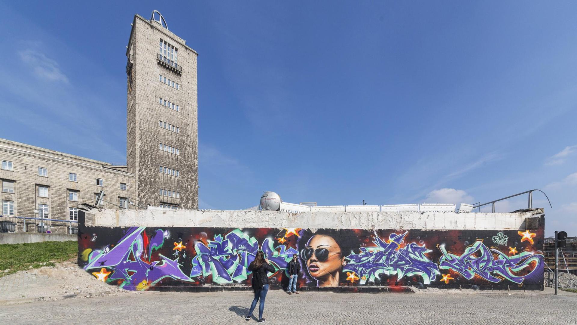 Eine Frau fotografiert ein Graffiti am Stuttgarter Hauptbahnhof. Eine Frau fotografiert ein Graffiti am Stuttgarter Hauptbahnhof.