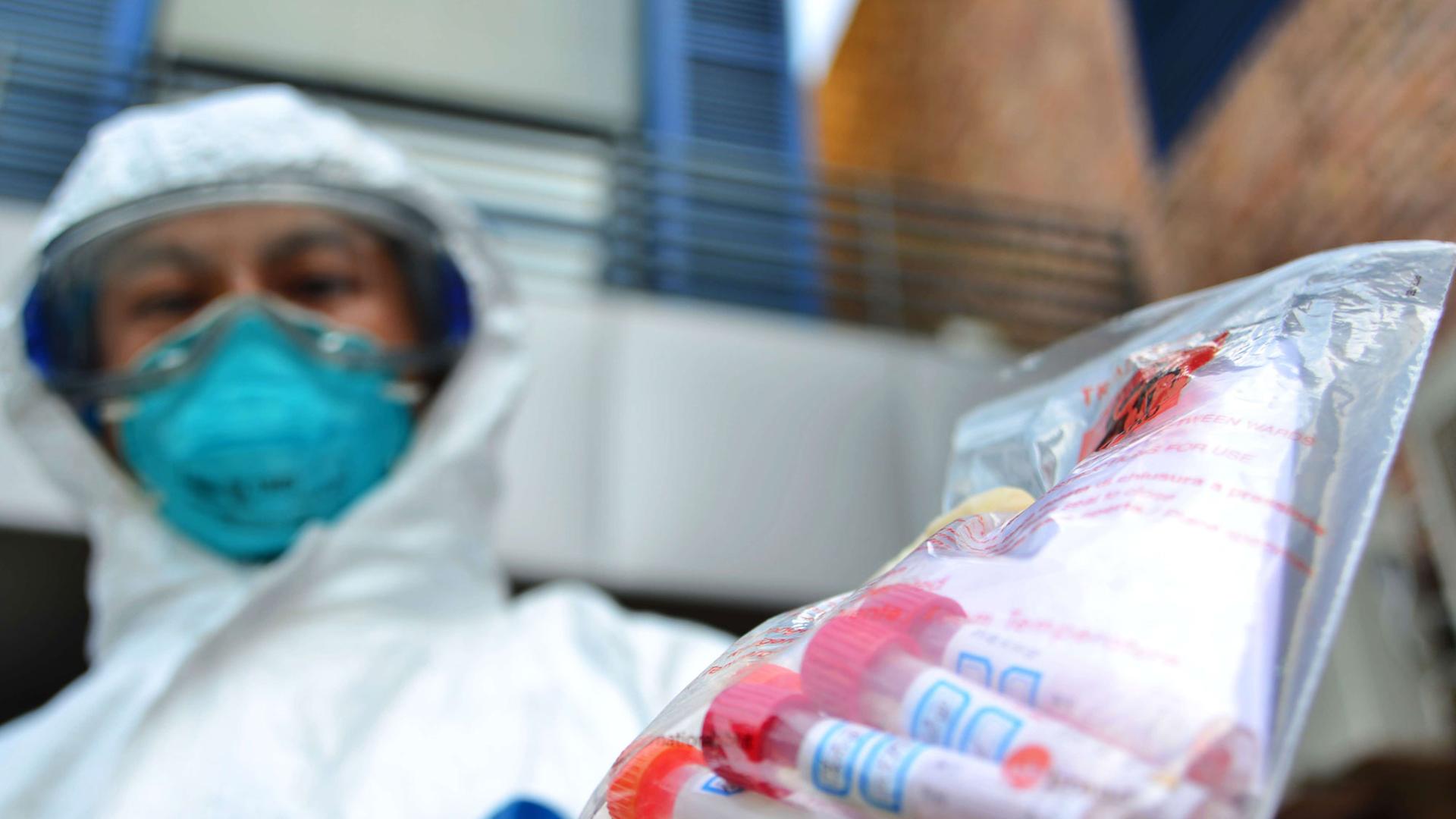 Ein Mitglied der Hongkou District Center for Disease Control & Prevention hat einen Beutel mit Proben des Vogelgrippevirus H7N9 in der Hand Ein Mitglied der Hongkou District Center for Disease Control & Prevention hat einen Beutel mit Proben des Vogelgrippevirus H7N9 in der Hand