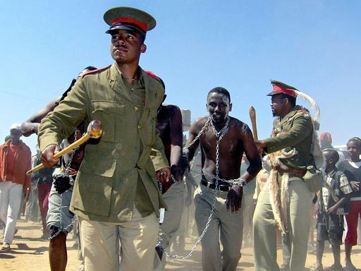 A performance shows the treatment of Hereros in 1904 at a ceremony commemorating the killing of thousands of Hereros by German troops, at Okakarara, 250 km northwest of Windhoek, Namibia, Saturday, 14 August 2004. Germany on Saturday asked the Herero people of Namibia to forgive it for the massacres committed by its troops during a three year uprising 100 years ago.