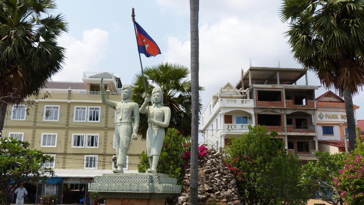 Junge und Mädchen als Denkmal mit Nationalfahne Junge und Mädchen als Denkmal mit Nationalfahne