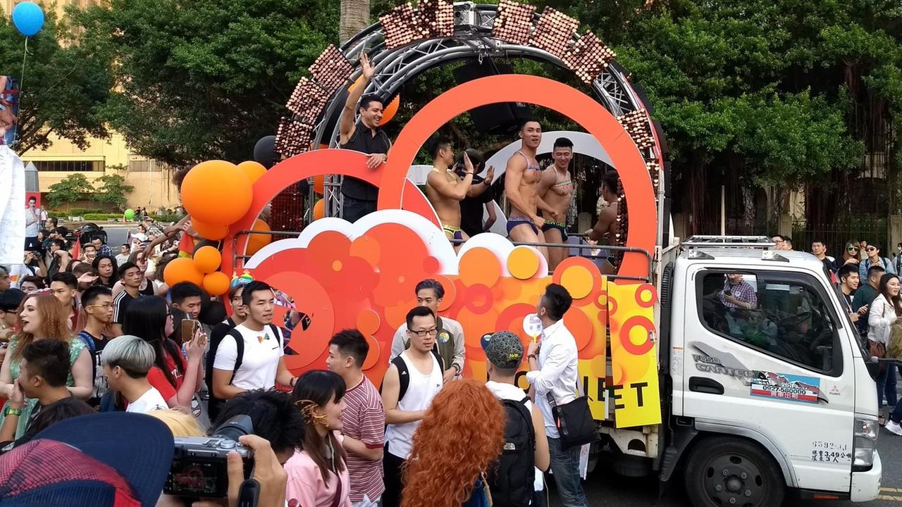 Ein Wagen auf der Gay Pride in Taipeh mit tanzenden Teilnehmern, die oberkörpferfrei sind.