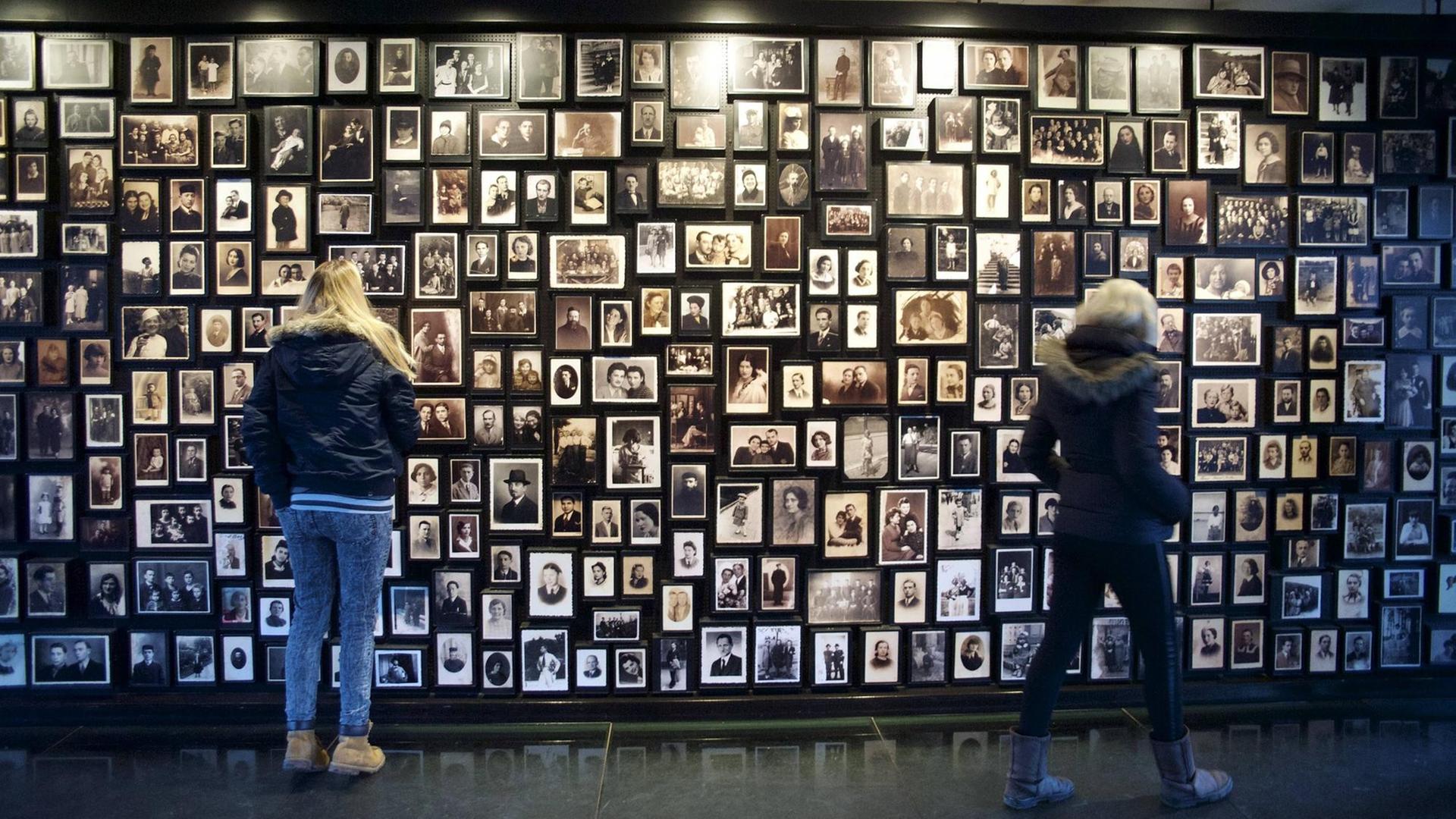 Schüler aus Deutschland betrachten Familienfotos von ermordeten Häftlingen im ehemaligen Konzentrationslager Auschwitz-Birkenau in Polen.