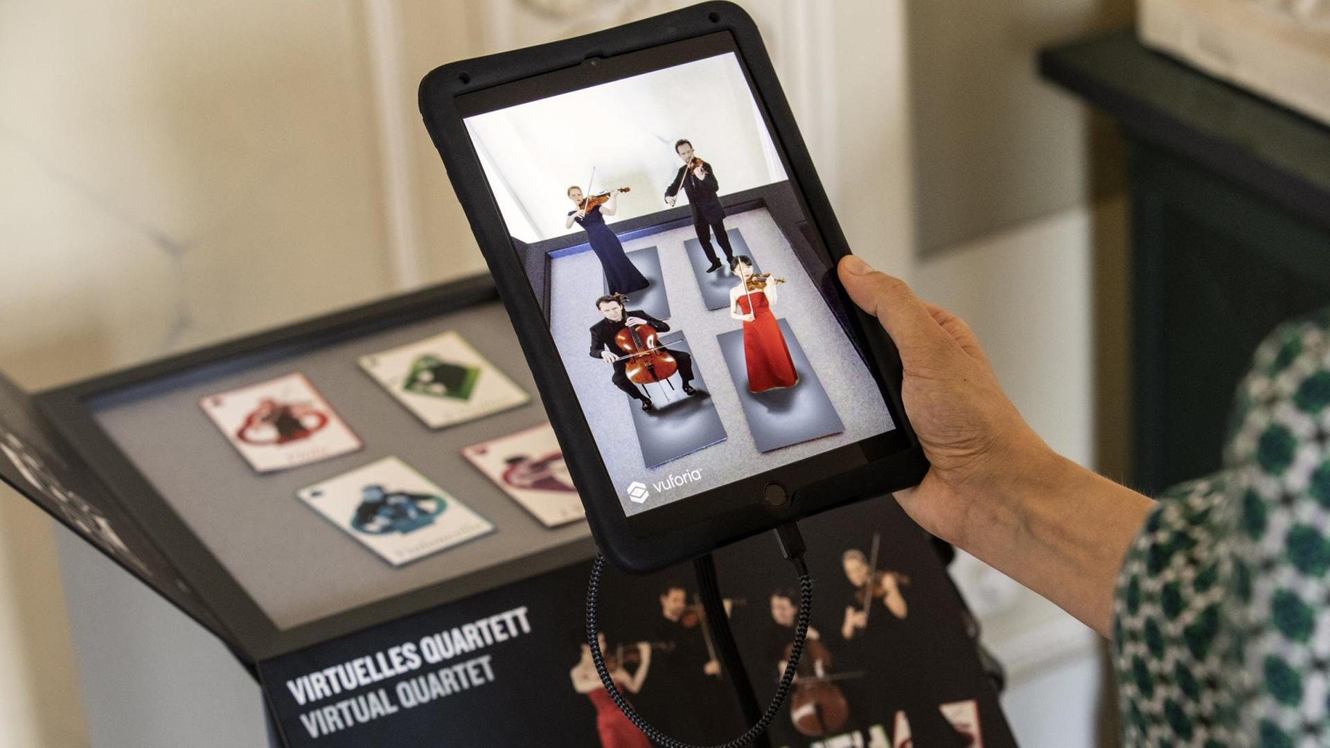 Besucher testen in Berlin die neue App "Konzerthaus Plus". Diese lässt via Augmented-Reality-Technologie vier virtuelle Musiker auf einem Tablet erscheinen, die den Anfang von Franz Schuberts "Der Tod und das Mädchen" spielen.