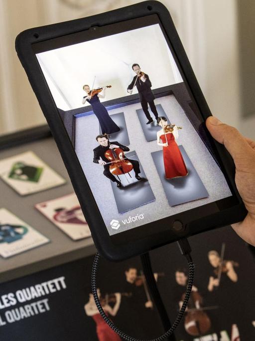 Besucher testen in Berlin die neue App "Konzerthaus Plus". Diese lässt via Augmented-Reality-Technologie vier virtuelle Musiker auf einem Tablet erscheinen, die den Anfang von Franz Schuberts "Der Tod und das Mädchen" spielen.