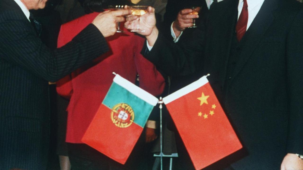 Der stellvertretende chinesische Außenminister Zhou Nan (r) und der portugiesische UN-Botschafter Rui Medina (l) prosten sich am 26. März 1987 in Peking nach der Unterzeichnung des Abkommens zu. Sie vereinbarten, daß Portugal seine Überseeprovinz Macao am 20. Dezember 1999 an die Volksrepublik China zurückgeben wird. |