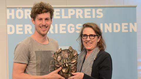 Lucas Derycke und Petra Müller (Geschäftsführerin der Film und Medienstiftung NRW) mit dem Hörspielpreis der Kriegsblinden 2017