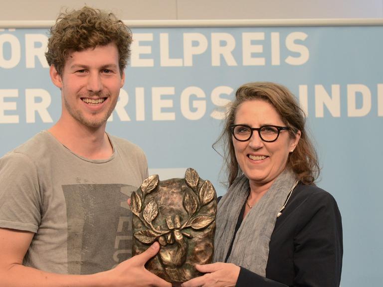 Lucas Derycke und Petra Müller (Geschäftsführerin der Film und Medienstiftung NRW) mit dem Hörspielpreis der Kriegsblinden 2017