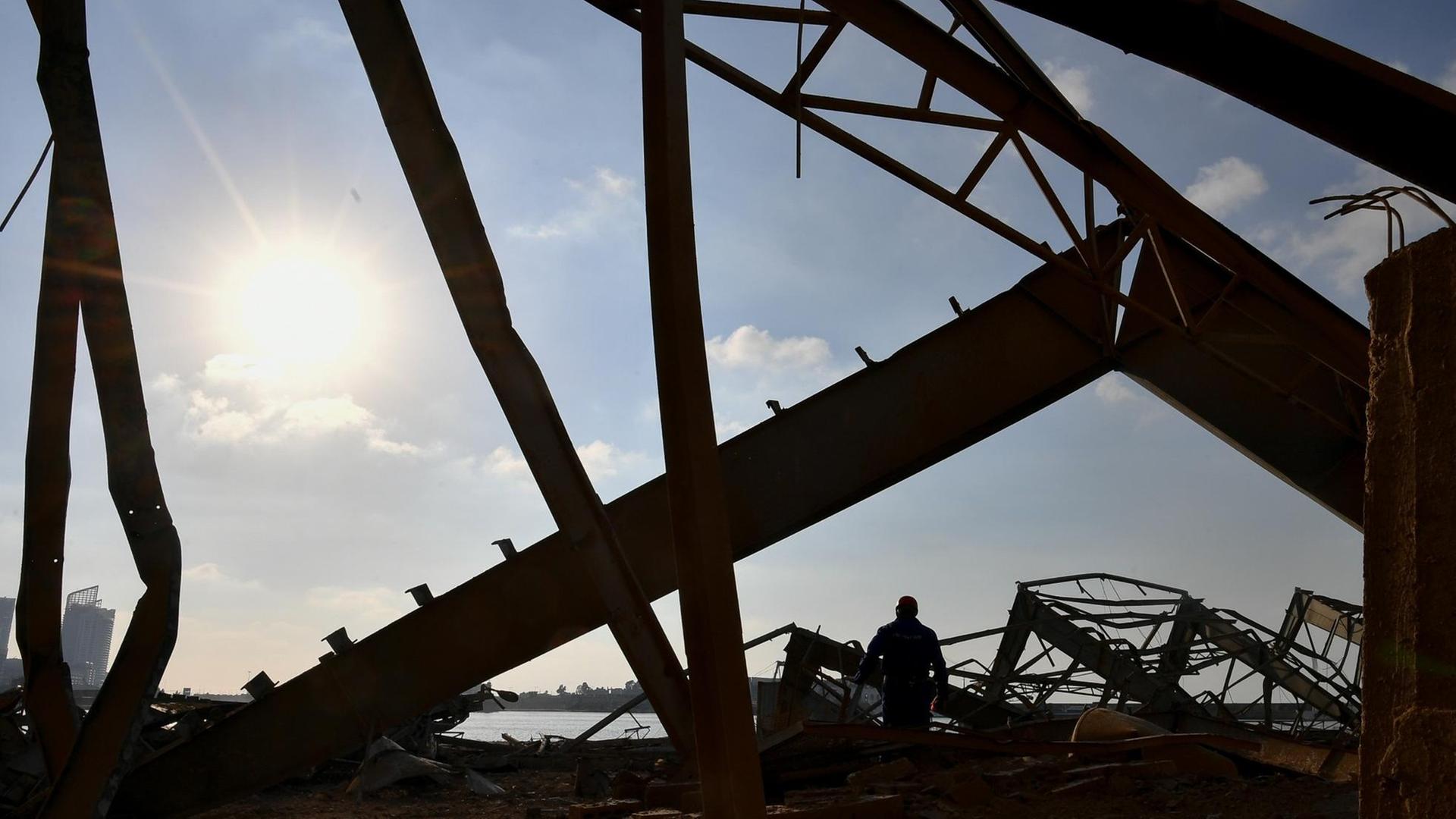 Beirut nach den Explosionen: Das Foto zeigt eine zerstörtes Bauwerk - Stahlträger sind im Gegenlicht zu sehen.