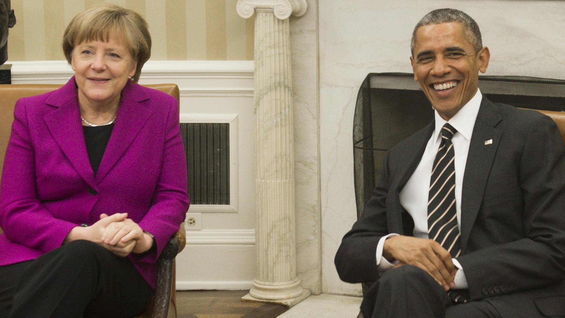 Bundeskanzlerin Angela Merkel und US-Präsident Barack Obama im Oval Office. Beide lachen in die Kameras.