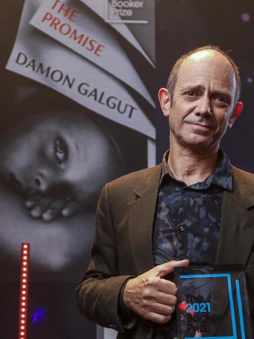 Damon Galgut mit der Trophäe des Booker Prize 2021.