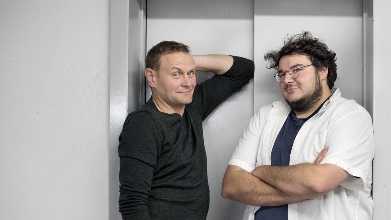 Devid Striesow und Axel Ranisch zusammen vor dem Aufzug. Devid Striesow und Axel Ranisch zusammen vor dem Aufzug.