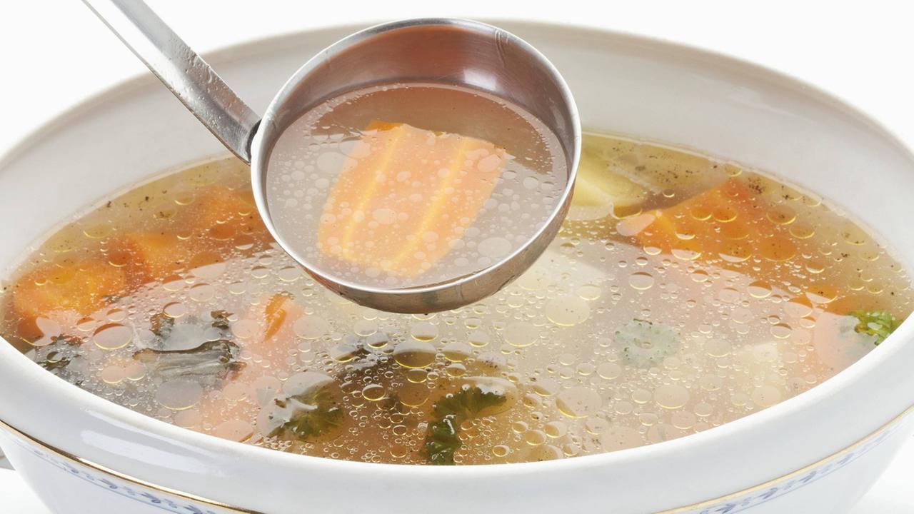 Eine Suppenterrine mit einer Hühnersuppe Eine Suppenterrine mit einer Hühnersuppe