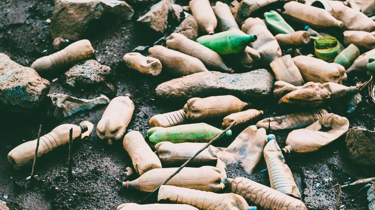 Dreckige Plastikflaschen auf dunkler Erde. Dreckige Plastikflaschen auf dunkler Erde.