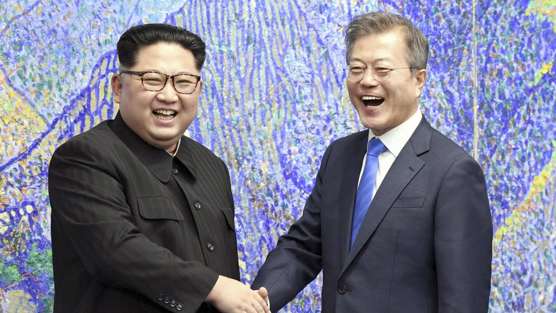 Südkoreas Präsident Moon Jae In (r) und Nordkoreas Machthaber Kim Jong Un schütteln einenader die Hände in der entmilitarisierten Zone von Panmunjeom