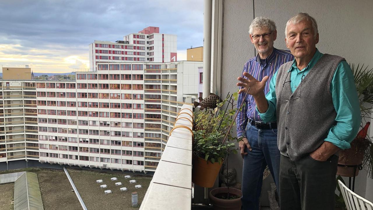 Zwei ältere Männer stehen auf einem der Balkone im Ihme-Zentrum.