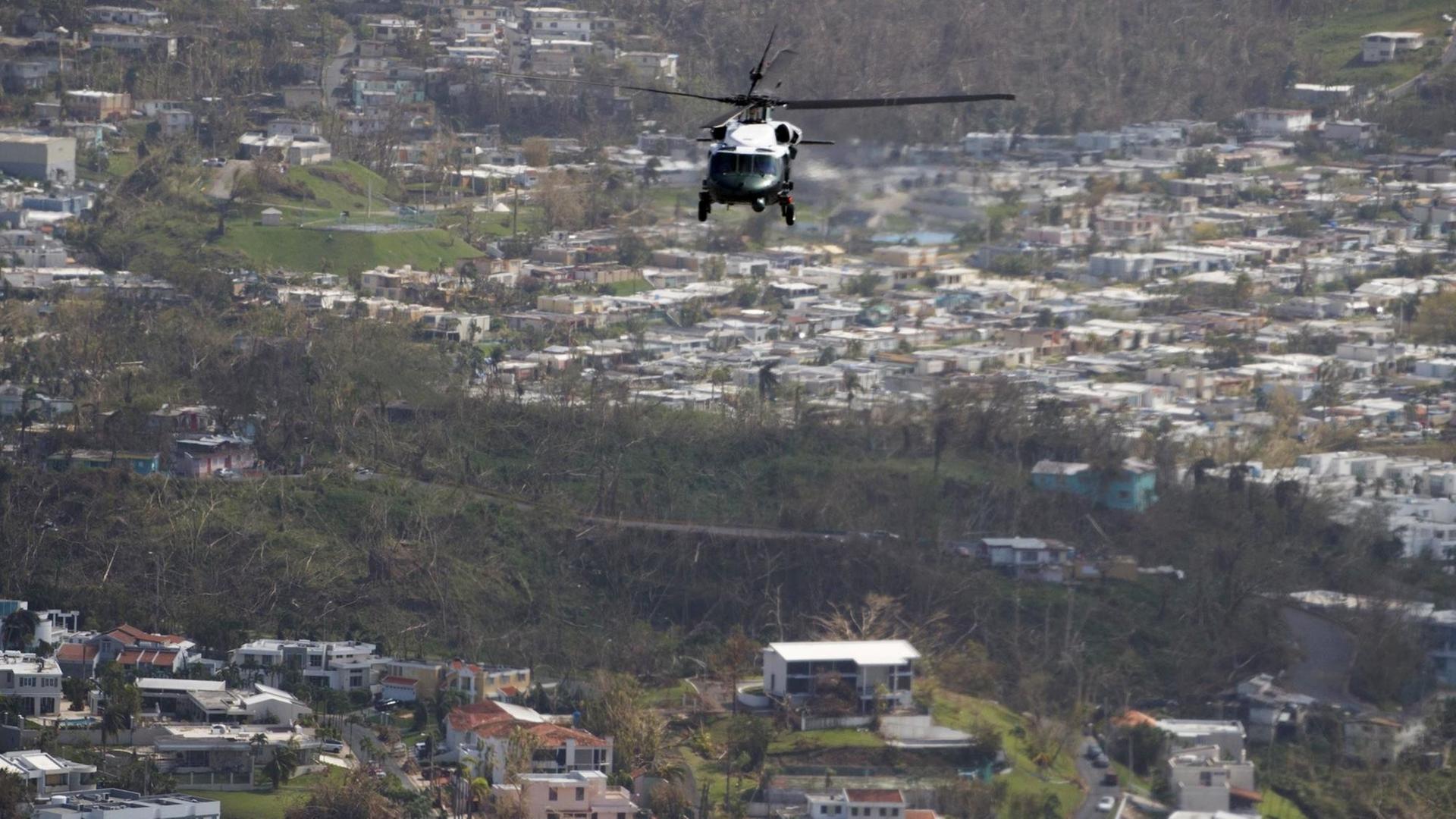 Ein Hubschrauber fliegt über eine besiedelte Landschaft. Ein Hubschrauber fliegt über eine besiedelte Landschaft.