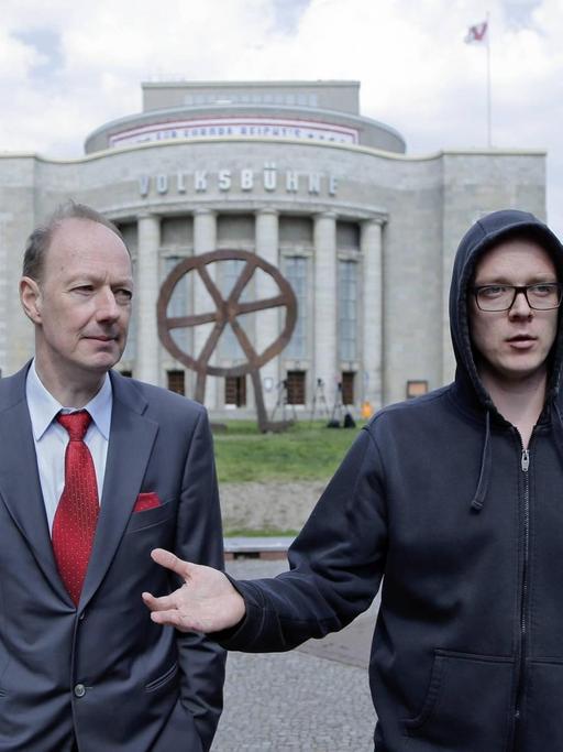 Martin Sonneborn im grauen Anzug und Nico Semsrott im dunklen Kapuzenpullover stehen während des Europa-Wahlkampfs 2019 vor dem Gebäude der Berliner Volksbühne.